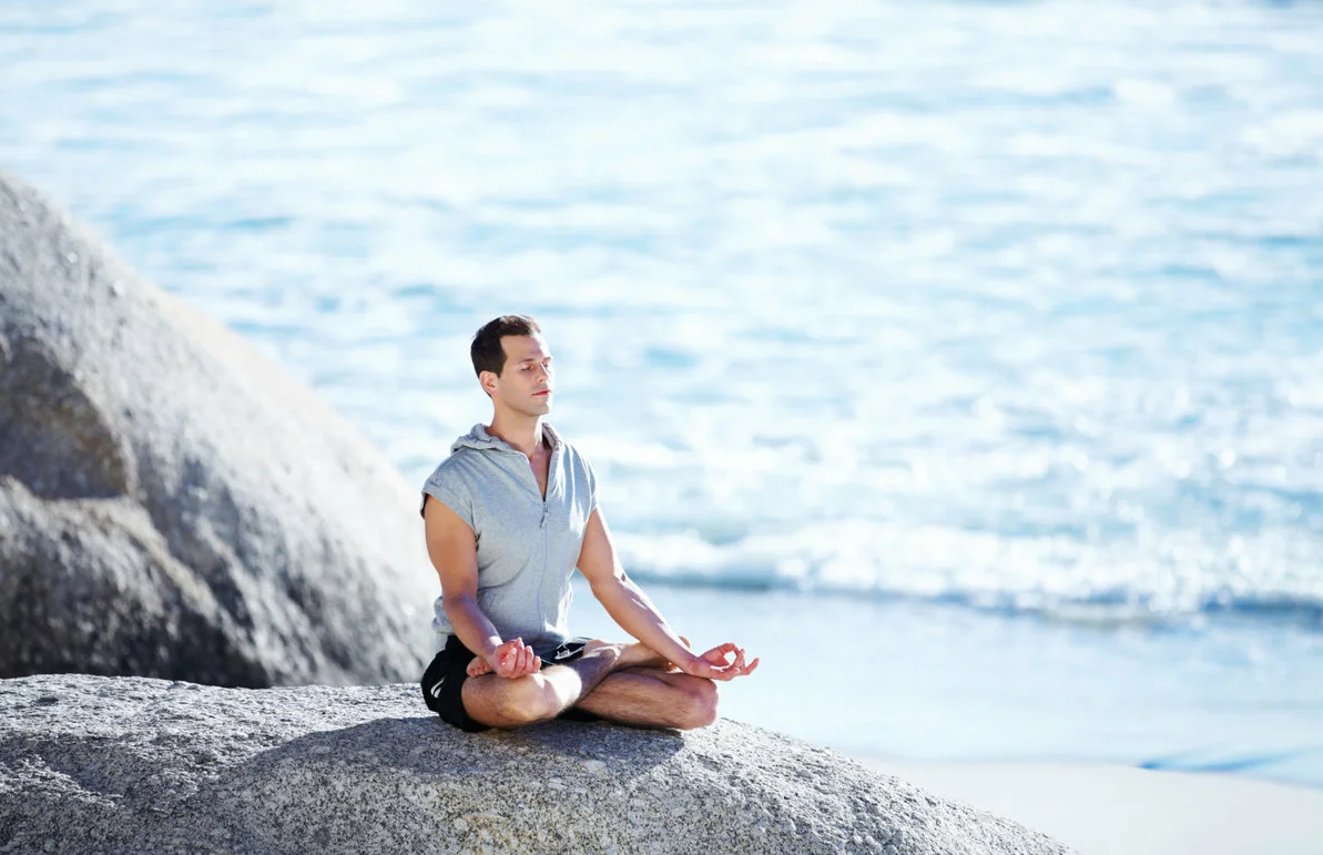 Медитация на счастливые события. Мужчина медитирует. Человек медитирует на море. Человек камень. Медитация мужчина.